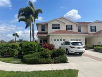Beautiful townhome with an attached garage, lush landscaping, and a paver driveway at 2334 Felicity Pl, North Port, FL 34289