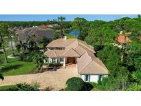 Stunning home with a tile roof, paver driveway, lush landscaping, and serene water views at 402 Walls Way, Osprey, FL 34229