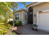 Inviting home entrance featuring a brick walkway, lush landscaping, and a charming flower display at 4134 63Rd E Ter, Sarasota, FL 34243