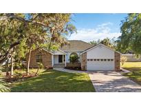 Charming single-story home featuring a brick and siding facade, a well-manicured lawn, and a two-car garage at 4444 Robin Hood Trl W, Sarasota, FL 34232