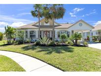 Inviting home with manicured lawn, lush landscaping, palm trees and attached portico at 4624 Blue Marlin Dr, Bradenton, FL 34208