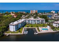 Aerial view of waterfront condos with a pool, marina, and beautiful water views at 600 Sutton Pl # 104, Longboat Key, FL 34228