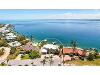 Stunning waterfront home with lush landscaping, private dock, and sparkling blue waters at 606 Crestwood Ln, Holmes Beach, FL 34217