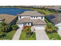 Beautiful two-story home with tile roof, attached two-car garage, mature landscaping, and water view at 6410 Rosehill Farm Run, Bradenton, FL 34211