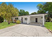 Charming single-story home featuring a covered carport, modern door, and well-maintained landscaping at 6639 16Th N St, St Petersburg, FL 33702