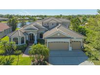Elegant home features a tile roof, three-car garage and a well manicured lawn at 6915 Honeysuckle Trl, Lakewood Ranch, FL 34202