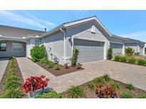 Charming home exterior with a well-manicured lawn and a two-car garage, offering great curb appeal at 9928 Bright Water Dr, Englewood, FL 34223