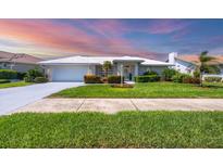 Charming single-story home featuring a lush green lawn and meticulously maintained landscaping at 1511 Waterford Dr, Venice, FL 34292