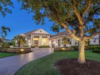 Stunning exterior view of a luxurious one-story home with lush landscaping and a paved driveway at 16407 Daysailor Trl, Lakewood Ranch, FL 34202
