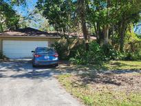 Charming single-story home with a spacious two-car garage and mature trees in the front yard at 1862 Orangewood Ln, Sarasota, FL 34232