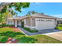 Charming single-story home with a well-maintained lawn and a two-car garage at 2407 Waterford Ct, Palmetto, FL 34221