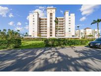 Stunning exterior view of a condo building with a manicured lawn, palm trees, and a car at 2625 Terra Ceia Bay Blvd # 506, Palmetto, FL 34221