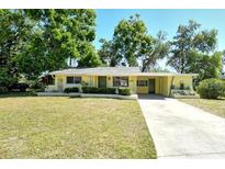 Charming one-story home featuring a well-manicured lawn and mature trees creating a peaceful setting at 4560 Brooksdale Dr, Sarasota, FL 34232