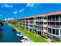 Beautiful waterfront condo building with boat docks, lush landscaping, and amazing views from multiple screened-in balconies at 1250 N Portofino Dr # 203, Sarasota, FL 34242