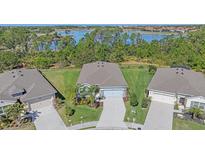 Stunning aerial view of a home with a well-manicured lawn and picturesque lake in the background at 13804 Camden Crest Ter, Lakewood Ranch, FL 34211