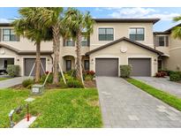 Inviting two-story home with a gray brick driveway, lush landscaping, and a two car garage at 15225 Lyla Ter, Bradenton, FL 34211