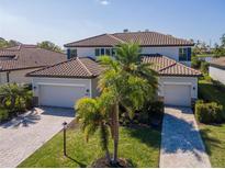 Charming two-story home featuring a brick paved driveway, two-car garage, and lush landscaping at 18013 Polo Trl, Bradenton, FL 34211