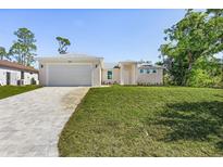 Charming single-story home with a well-manicured lawn and paved driveway leading to a spacious garage at 2364 Carpenter Ln, North Port, FL 34286