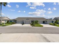 Charming villa with lush landscaping, well-manicured lawns, and a double driveway leading to attached garages at 2908 Fiddlers Bnd, Palmetto, FL 34221