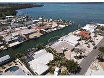 Waterfront home with private dock, screened pool, and lush landscaping on a sunny day at 3708 Plumosa Ter, Bradenton, FL 34210