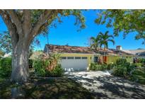 Charming single-story home with a two-car garage, manicured landscaping, and a bright yellow exterior at 4662 Long Lake Dr, Sarasota, FL 34233