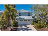 Charming two-story home with a two car garage, metal roof, and lush tropical landscaping at 4922 Commonwealth Dr, Sarasota, FL 34242