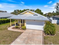 Beautiful one-story home with yellow siding, a gray roof, and an attached two-car garage at 5319 Levi Ln, Sarasota, FL 34233