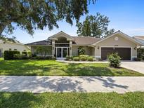 Beautiful single-story home with mature landscaping, manicured lawn, and a two-car garage at 555 Park Estates Sq, Venice, FL 34293