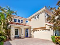 Beautiful two-story home featuring a well-manicured lawn, blue front door, and a two-car garage at 12518 Harbour Landings Dr, Cortez, FL 34215