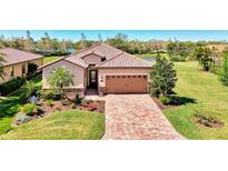 Charming single-Gathering home boasting a brick paved drive, manicured lawn and lush landscaping for enhanced curb appeal at 167 Wandering Wetlands Cir, Bradenton, FL 34212