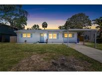 Charming single-story home with a carport and a well-manicured lawn under a beautiful dusk sky at 1827 Nevada Ne Ave, St Petersburg, FL 33703