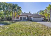Charming single-story home with lush front lawn and mature trees providing shade and curb appeal at 2301 Bern Creek Loop, Sarasota, FL 34240