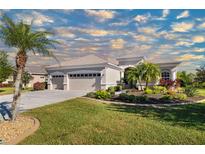 Charming single-story home featuring a well-manicured lawn, lush landscaping, and a three-car garage at 391 Snapdragon Loop, Bradenton, FL 34212