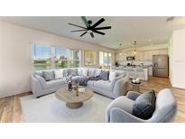Bright and spacious living room with lake views, modern decor, and an open concept connecting to the kitchen at 10614 Morning Marsh Ln, Parrish, FL 34219