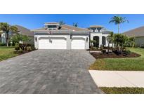 Charming home featuring a paver driveway, well-manicured lawn, and a two-car garage at 12352 Auburndale Ct, Venice, FL 34293