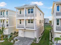 Charming three-story home with double balconies, landscaped yard, and a paved driveway at 12413 Gulf Breeze Ter, Cortez, FL 34215