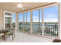 Balcony view with tiled floor, ceiling fan and sliding glass doors overlooking water and boats at 1260 Dolphin Bay Way # 404, Sarasota, FL 34242