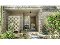 Charming front entrance featuring a glass door, neutral tones, and inviting landscaping at 1610 Treehouse Cir # T130, Sarasota, FL 34231