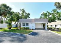 Charming single-story home featuring a well-kept lawn, covered carport, and mature landscaping at 2332 Canalbluff Pl # 298, Sarasota, FL 34231