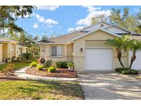 Charming single-story home with a well-manicured lawn, a two-car garage and beautiful landscaping in a warm-toned color palette at 411 28Th W St, Palmetto, FL 34221