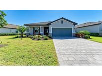 Charming one-story home with a paved driveway, two-car garage, and beautifully landscaped front yard at 5129 Marina Basin Ct, Bradenton, FL 34211