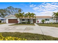 Charming single-story home with a beautiful tiled roof, well-manicured landscaping, and a spacious driveway at 611 Dundee Ln, Holmes Beach, FL 34217