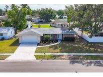 Charming brick home featuring a well-manicured lawn, attached garage, and inviting curb appeal at 6637 Bowline Dr, Sarasota, FL 34231