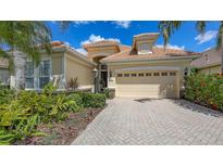 Beautiful home with a well-maintained lawn, lush landscaping, and a paved driveway leading to a two-car garage at 7137 Orchid Island Pl, Bradenton, FL 34202