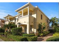 Elegant two-story home featuring a decorative balcony, lush landscaping, and a well-manicured walkway at 7665 Bergamo Ave, Sarasota, FL 34238