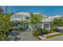 Beautiful two-story home with white tile roof, lush landscaping and paver driveway at 7782 Club Ln, Sarasota, FL 34238