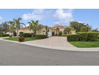 Beautiful Mediterranean home with lush landscaping, paver driveway, and tile roof in a sunny setting at 8024 Via Fiore, Sarasota, FL 34238