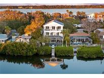 Waterfront home showcasing its multi-level balconies, private dock, lush landscaping, and serene water views at 8258 Midnight Pass Rd, Sarasota, FL 34242
