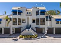 Condo building with private garages, lush landscaping, and vibrant blue accents at 1912 Harbourside Dr # 602, Longboat Key, FL 34228
