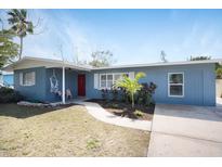 Charming single-story home with a blue exterior, red door, and well-maintained front yard at 2001 25Th W Ave, Bradenton, FL 34205